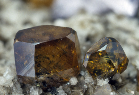 Flächenreicher Anatas| (Kantenlänge bis 3 mm) mit wenig eingeschlossenem dünntafeligem Hämatit aus einer Kluft, in der die frühgebildeten Fe-Ti-Minerale weitgehend fehlen 