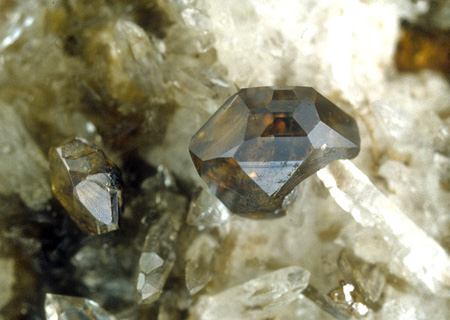 Flächenreicher Anatas x auf Quarz| (Anatas Durchmesser 3 mm); Bemerkenswerter Weise ist nur eine Seite des Kristalls flächenreich ausgebildet. Hier treten zusätzlich eine ditetragonale Bipyramide und drei Bipyramiden in Erscheinung 